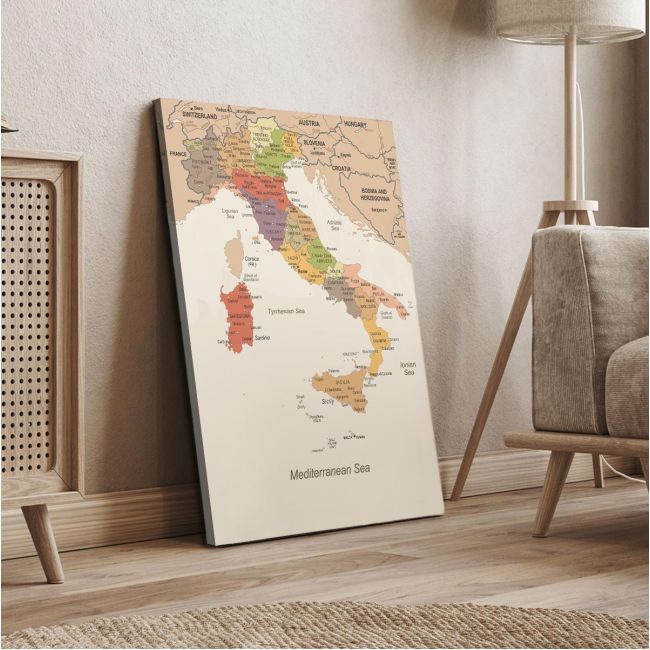 Italy map canvas print, vintage style, leaning on beige wall next to wooden furniture.