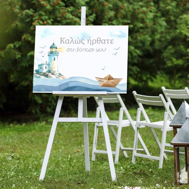 Baptism welcome canvas featuring lighthouse, paper boat, waves. On white easel, set outdoors on grass.