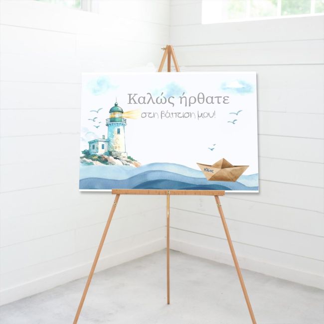Canvas baptism welcome sign, lighthouse, paper boat 'Ηλίας', waves. On wooden easel, white paneled wall.