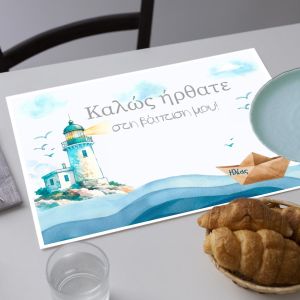 Paper baptism placemat: lighthouse, waves, paper boat. Set on a white table. 2
