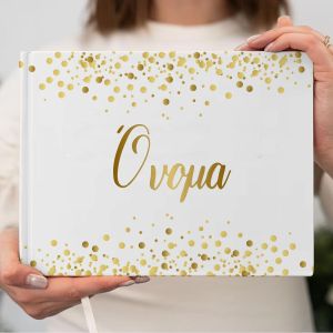 Βιβλίο ευχών σκληρόδετο, λευκό, με χρυσά κομφετί και 'Όνομα'. Μίνιμαλ, κομψό, σε χέρια.