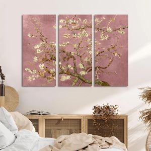 Triptych canvas print of Van Gogh's Almond Blossom on a pink background, above a wooden cabinet in a bedroom.