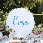 White wooden round sign 'Name' for boys, at outdoor candy bar. Minimalist, elegant design.