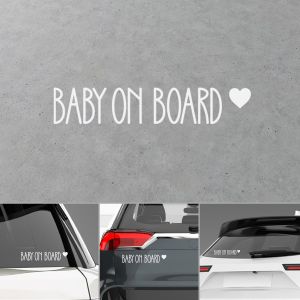 Αυτοκόλλητο βινυλίου "Baby on Board ♥", γραφή χεριού. Επίδειξη σε γκρι φόντο και εφαρμογή σε όχημα. 2