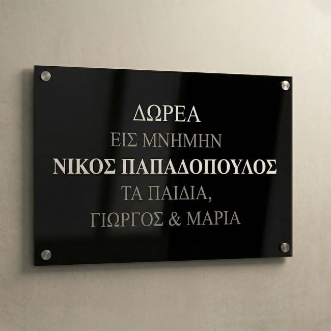 Commemorative plaque, black Plexiglass with UV printed silver text, wall-mounted with standoffs on a light wall.