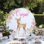 Κυκλική ξύλινη πινακίδα candy bar με ελαφάκι, ροζ λουλούδια, Όνομα και ημερομηνία σε κήπο.