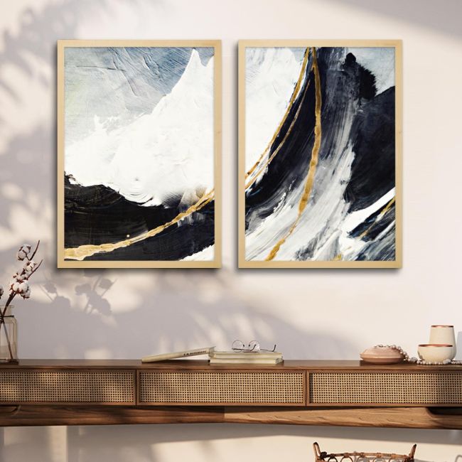 Diptych canvas art with abstract mountains and golden lines, on wall above wooden furniture.
