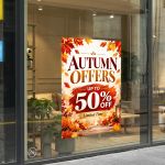 Autumn offers window sticker on store glass with fall leaves and pumpkins