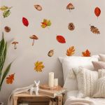 Autumn leaves wall stickers on beige wall above a bed with white pillows.